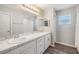 Bathroom with double sinks, large mirror, white cabinetry, and wood-look flooring at 13814 Harvestwood Ln, Riverview, FL 33569