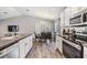 Bright kitchen with stainless steel appliances, white cabinets, and a view into the dining area at 13814 Harvestwood Ln, Riverview, FL 33569