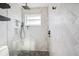 Modern shower featuring sleek fixtures, stone flooring, and stylish herringbone tile at 1399 49Th Ne Ave, St Petersburg, FL 33703