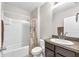 Well-lit bathroom featuring a shower-tub combo and a single sink vanity with dark wood cabinets at 14135 Arbor Pines Dr, Riverview, FL 33579