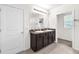 Bright bathroom with dual sinks, a large mirror, and dark wood cabinets at 14135 Arbor Pines Dr, Riverview, FL 33579