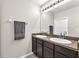 Well-lit bathroom featuring dual sinks, a large mirror, and dark wood cabinets at 14135 Arbor Pines Dr, Riverview, FL 33579