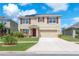 Two-story home with a two-car garage, solar panels, and well-manicured landscaping at 14135 Arbor Pines Dr, Riverview, FL 33579