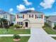 Two-story home featuring solar panels, a two-car garage, and manicured landscaping at 14135 Arbor Pines Dr, Riverview, FL 33579
