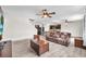 Open-concept living room featuring gray tile flooring, ceiling fans, and a brown leather sofa set at 14135 Arbor Pines Dr, Riverview, FL 33579