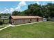 Exterior view of the home with a simple, well-maintained lawn and neutral paint at 14312 1St St, Dade City, FL 33525