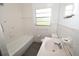 Bathroom featuring white tiles, a bathtub, and a classic sink and vanity at 14312 1St St, Dade City, FL 33525