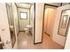 Cozy bathroom features a toilet, sink, framed mirror and neutral tile flooring at 14312 1St St, Dade City, FL 33525