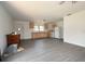Open-concept kitchen and living area with new gray flooring, basic appliances, and natural wood cabinets at 14312 1St St, Dade City, FL 33525