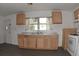 A functional kitchen space with light wood cabinets and a view to the outside at 14312 1St St, Dade City, FL 33525