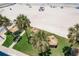Beachside property featuring green grass, palm trees, tiki huts, and a white sand beach, ideal for coastal living at 17500 Gulf Blvd # 407, Redington Shores, FL 33708