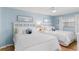 Bright bedroom with two beds, coastal decor, ceiling fan, and ample natural light creating a serene space at 17500 Gulf Blvd # 407, Redington Shores, FL 33708