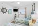 Bright bedroom featuring twin beds, TV, nautical decor, and sunlit window at 17500 Gulf Blvd # 407, Redington Shores, FL 33708