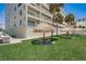 A beautiful lawn and outdoor area with tiki hut-covered picnic tables next to the condo building at 17500 Gulf Blvd # 407, Redington Shores, FL 33708