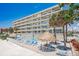 Condo building with pool, beach, lounge chairs and picnic huts at 17500 Gulf Blvd # 407, Redington Shores, FL 33708