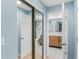 Hallway leading to the bathroom with mirrored closet doors and tile flooring at 17500 Gulf Blvd # 407, Redington Shores, FL 33708