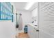 Practical laundry room with a washer, dryer, storage cabinets, and beach themed decor at 17500 Gulf Blvd # 407, Redington Shores, FL 33708