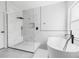 Sleek bathroom with glass enclosed shower and soaking tub with matte black fixtures at 18036 Java Isle Dr, Tampa, FL 33647