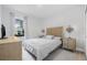 Bright bedroom featuring a woven headboard, accent lamps, and a large window at 18036 Java Isle Dr, Tampa, FL 33647