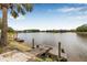 Picturesque lake view with a charming old dock offering a glimpse of the waterfront lifestyle at 18036 Java Isle Dr, Tampa, FL 33647