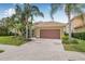 Charming single-story home with a beautiful tile roof, brick driveway, and lush tropical landscaping at 18036 Java Isle Dr, Tampa, FL 33647