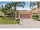 Charming single-story home with a beautiful tile roof, brick driveway, and lush tropical landscaping at 18036 Java Isle Dr, Tampa, FL 33647
