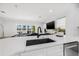 Modern kitchen showcasing a quartz countertop, black sink, and open layout to the living room at 18036 Java Isle Dr, Tampa, FL 33647