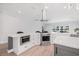 Modern kitchen with stainless steel appliances, white cabinets, an island, and a large window at 18036 Java Isle Dr, Tampa, FL 33647