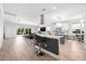 Open-concept kitchen featuring a large island with bar seating, modern lighting, and stainless steel appliances at 18036 Java Isle Dr, Tampa, FL 33647