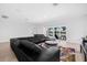 Bright living room with black leather sectional sofa, colorful rug and water view at 18036 Java Isle Dr, Tampa, FL 33647