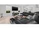 Open-concept living room featuring a sleek entertainment center, a black leather sofa, and kitchen view at 18036 Java Isle Dr, Tampa, FL 33647