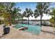Inviting pool and spa area with travertine tile and serene lake views at 18036 Java Isle Dr, Tampa, FL 33647