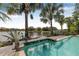 Beautiful pool featuring bar seating overlooking a serene lake surrounded by tropical plants and other homes at 18036 Java Isle Dr, Tampa, FL 33647