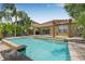 Inviting backyard pool with tropical landscaping, waterfall features, and a covered patio perfect for outdoor entertaining at 18036 Java Isle Dr, Tampa, FL 33647