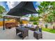 Outdoor patio featuring comfortable seating, a dining set, outdoor umbrella, and a well-manicured lawn at 18504 Country Crest Pl, Tampa, FL 33647
