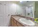 Bathroom featuring a laminate countertop, oak cabinets and a large frameless mirror at 18504 Country Crest Pl, Tampa, FL 33647