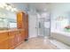 Bright bathroom features a tiled floor, shower, vanity, jetted tub, and linen storage at 18504 Country Crest Pl, Tampa, FL 33647