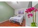 Bright bedroom with hardwood floors, a large window, and a queen-size bed with a white quilted comforter at 18504 Country Crest Pl, Tampa, FL 33647