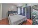 Cozy bedroom featuring neutral gray walls, hardwood floors, a modern dresser, and a comfortable bed at 18504 Country Crest Pl, Tampa, FL 33647