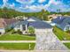 Well-manicured home exterior with a three car garage, paver driveway, and nicely landscaped front yard at 18504 Country Crest Pl, Tampa, FL 33647