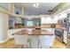 Bright, open kitchen features island, white cabinets, granite counters, and stainless appliances at 18504 Country Crest Pl, Tampa, FL 33647