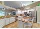 Spacious kitchen boasts white cabinets, stainless appliances, and granite countertops on island at 18504 Country Crest Pl, Tampa, FL 33647