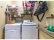 Functional laundry room with a washer and dryer, wire racks, and convenient storage shelves at 18504 Country Crest Pl, Tampa, FL 33647