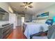 Primary bedroom with wood floors, ceiling fan, ensuite bathroom, and coastal decor at 18504 Country Crest Pl, Tampa, FL 33647