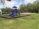 Community playground with slides and play structures on a mulch bed, with a sand volleyball court in the background at 18504 Country Crest Pl, Tampa, FL 33647