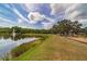 Community playground with a lake and fountain in the background, surrounded by a lush green landscape at 18504 Country Crest Pl, Tampa, FL 33647
