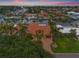 Aerial view of a waterfront estate showcasing the red tile roof, circular driveway, and lush landscaping at 1931 Kentucky Ne Ave, St Petersburg, FL 33703