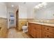 Bathroom with stone-like tiles, wooden vanity with granite counters, and tiled shower at 1931 Kentucky Ne Ave, St Petersburg, FL 33703