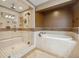 Updated bathroom with a frameless glass shower, tub with tile surround, and updated fixtures at 1931 Kentucky Ne Ave, St Petersburg, FL 33703