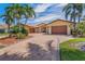 Beautiful yellow stucco home with a tile roof, circular driveway, and tropical landscaping at 1931 Kentucky Ne Ave, St Petersburg, FL 33703